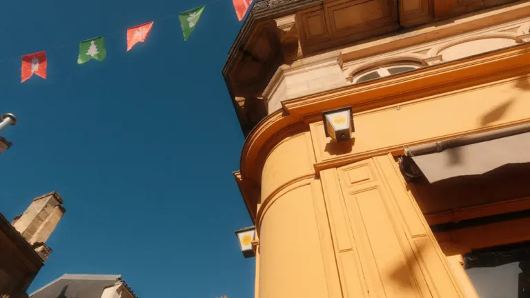 Vue architecturale en contre-plongée avec drapeaux festifs dans une rue de Bordeaux.