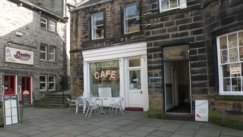 Une terrasse de café accueillante sur une rue pavée en ville européenne.