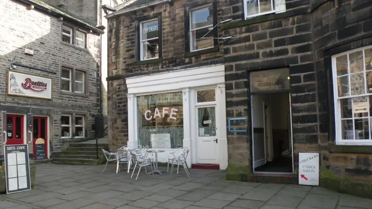 Une terrasse de café accueillante sur une rue pavée en ville européenne.