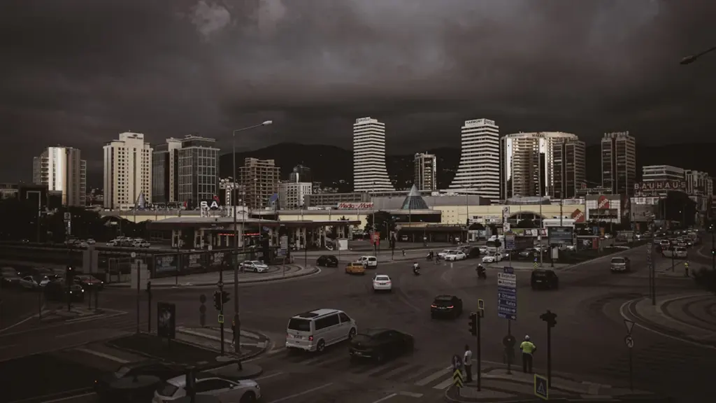 Vue plongeante sur un carrefour urbain animé sous un ciel orageux menaçant.
