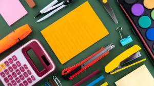 Un ensemble de fournitures scolaires sur un bureau avec un espace de copie vide.