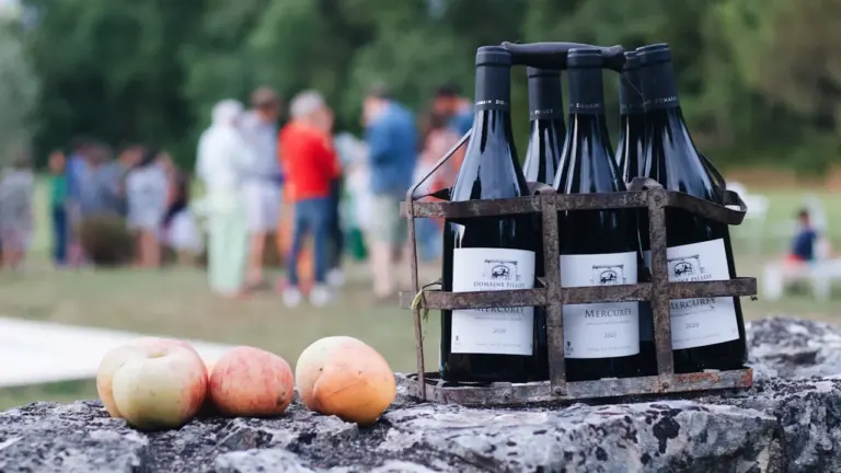 Bouteilles de vin sur un muret lors d'un événement festif à Dijon.