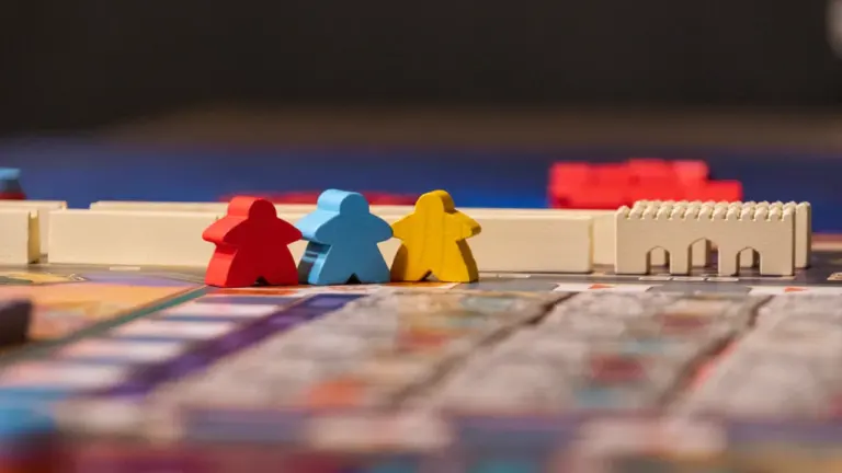 Des pions de jeu de société colorés posés sur un plateau de jeu.
