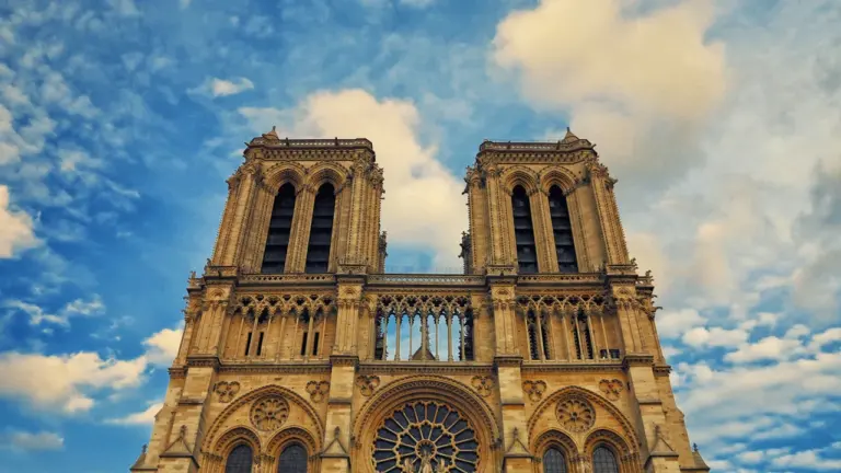 Vue monumentale de la cathédrale Notre-Dame de Paris sous un ciel bleu dégagé.
