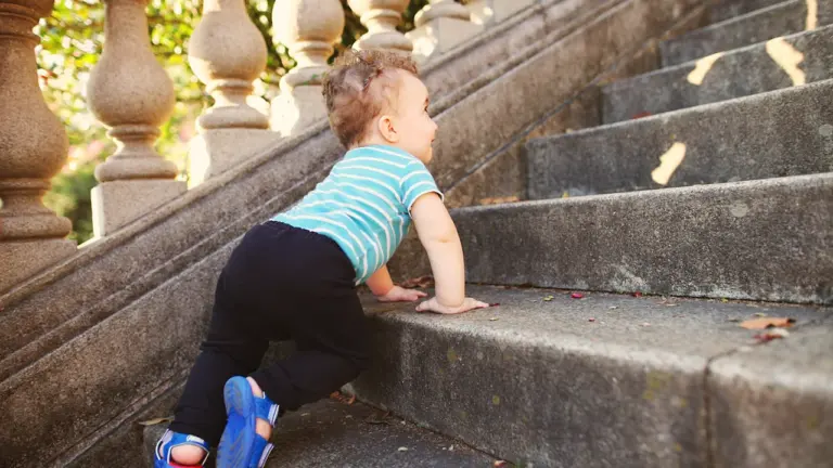 Un jeune enfant monte les escaliers, évoquant les premiers pas de l'enfance.