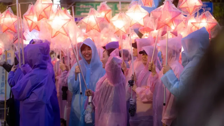 Groupe de personnes portant des imperméables colorés lors d'une fête locale en extérieur.