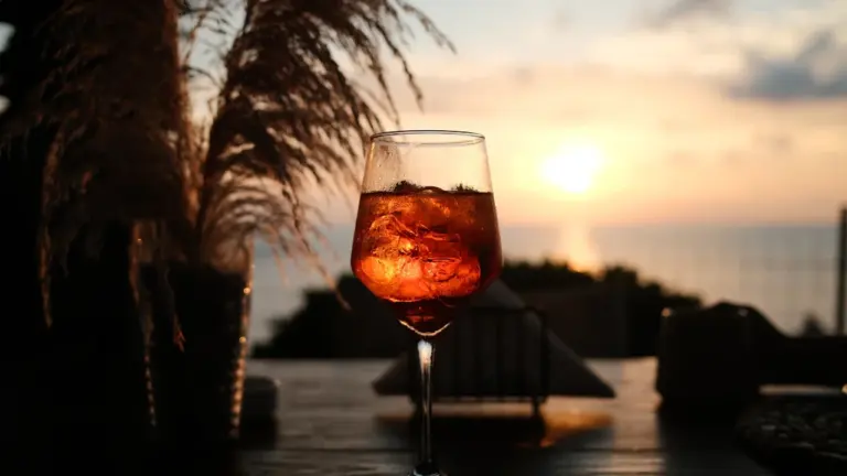 Un verre d'Aperol Spritz frais sur une table au coucher du soleil.