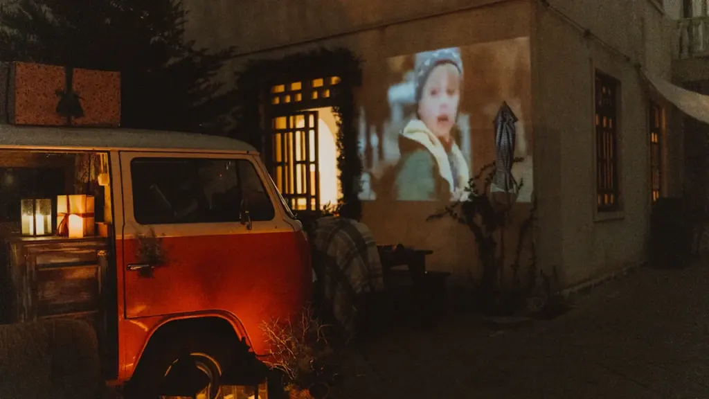 Une projection cinématographique en plein air contre un mur avec une ambiance chaleureuse.