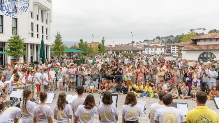 Un groupe de jeunes musiciens jouant devant une foule nombreuse sur une place publique.