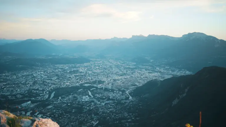Vue panoramique d'une ville nichée dans une vallée alpine au coucher du soleil
