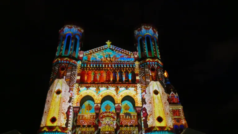 Façade illuminée de la cathédrale lors d'un spectacle nocturne haut en couleurs.
