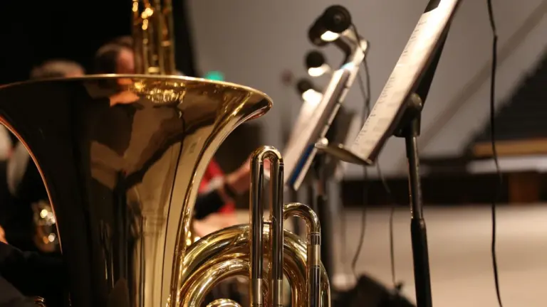 Gros plan sur un tuba et des partitions lors d'une répétition musicale.