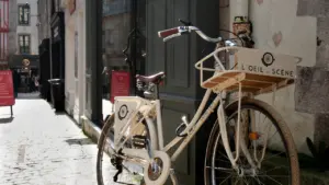 Un vélo de ville stationné devant un commerce dans une rue pavée française.
