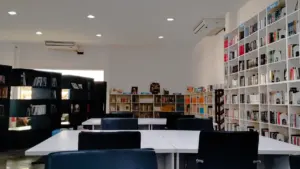 Aménagement intérieur d'une bibliothèque moderne avec étagères remplies et tables de travail.